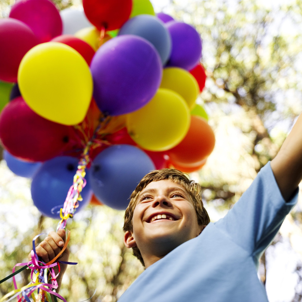 Young Boy Holding a String of Balloons